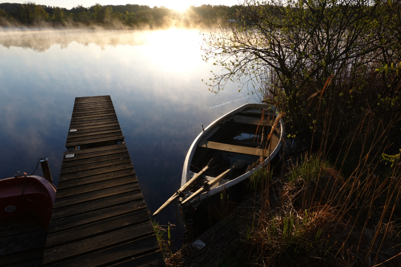 Boot am Morgen im Nebel an See